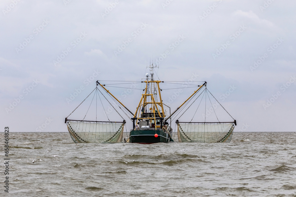 A fishing boat on the north sea at a cloudy day in summer