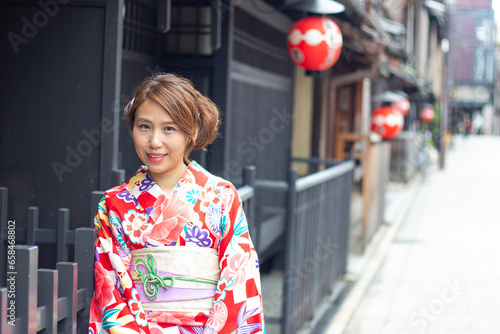 Beautiful girl wearing a colourful kimono (Japanese Traditional dress), smiling and looking to the camera in Gion, Kyoto, Japan. 