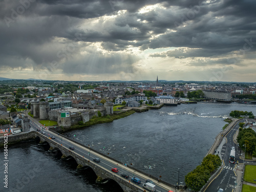 King John castle in Limerick Ireland on the banks of the Shannon river next to the Thomond bridge with dramatic cloudy sky photo