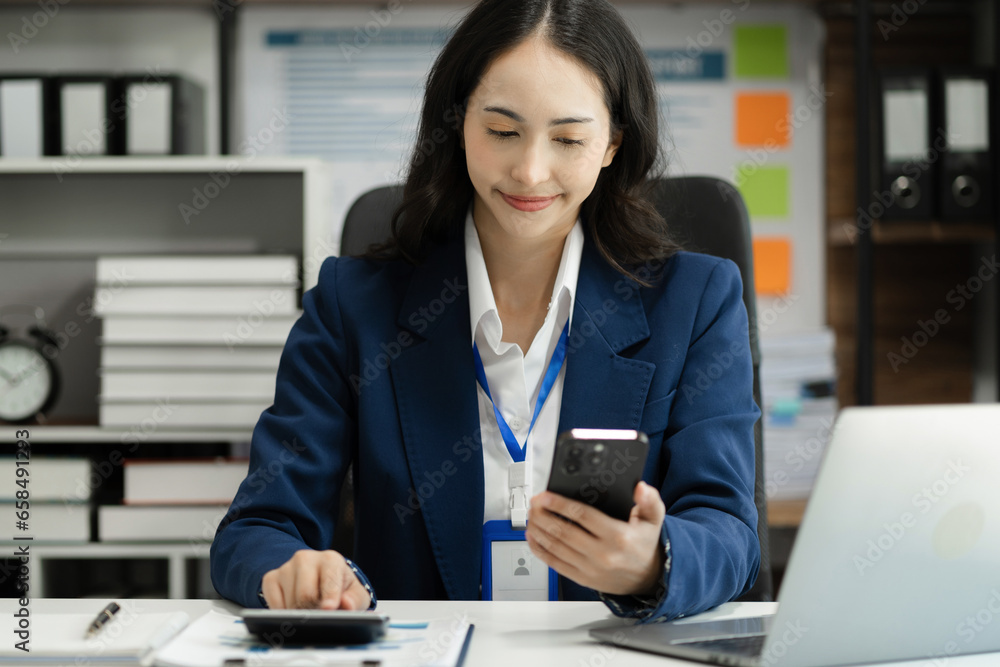 Business woman working on laptop and accounting financial report, accountant using calculator to calculate tax refund at office. Business woman working on laptop and accounting financial report, accountant using calculator to calculate tax refund at office.