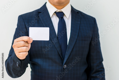 Businessman holding blank business card .