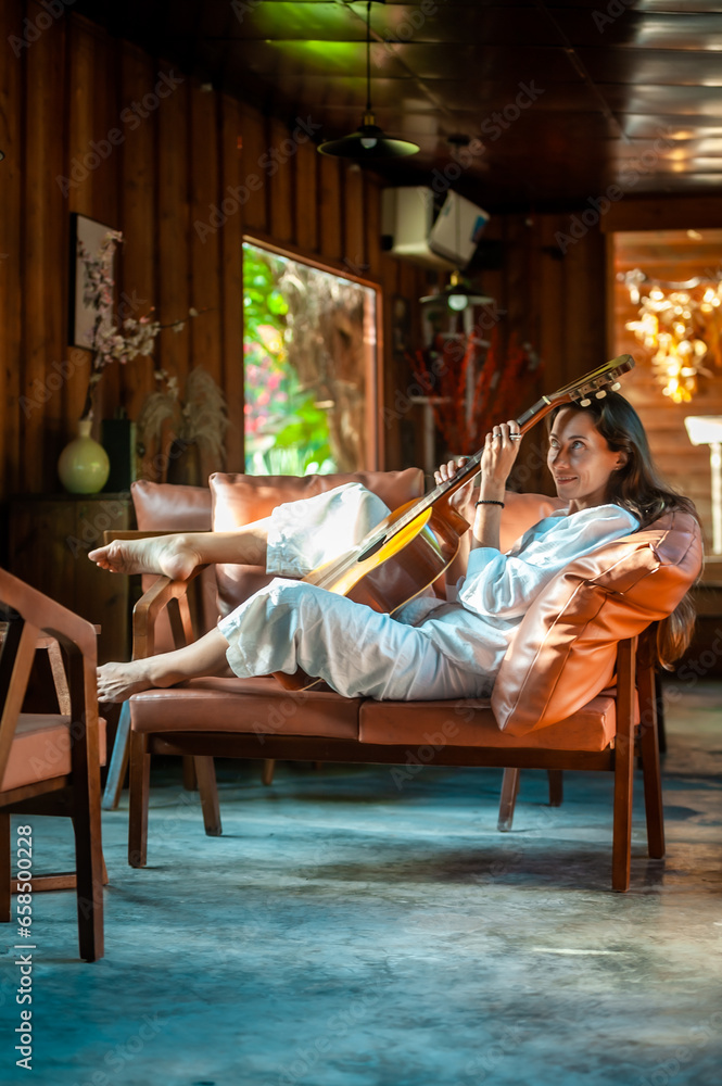 woman okaying posing with guitar in restaurant cafe