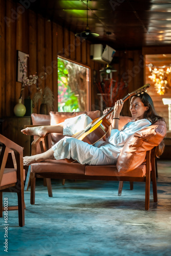 woman okaying posing with guitar in restaurant cafe