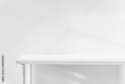 Empty white desk with morning light and shadows of windows with copy space, summer concert. Blurred backdrop abstract background for display product.