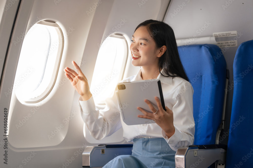 Using tablet pc, Thoughtful asian people female person onboard, airplane window, perfectly capture the anticipation and excitement of holiday travel. chinese, japanese people. Using tablet pc, Thoughtful asian people female person onboard, airplane window, perfectly capture the anticipation and excitement of holiday travel. chinese, japanese people.