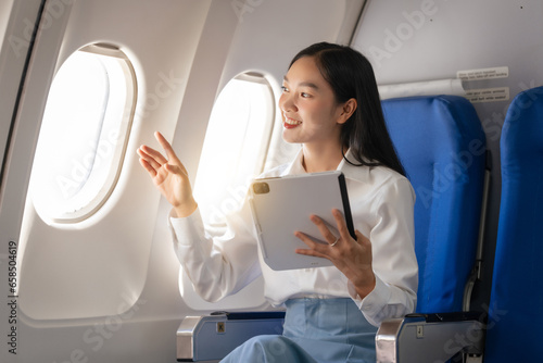 Using tablet pc, Thoughtful asian people female person onboard, airplane window, perfectly capture the anticipation and excitement of holiday travel. chinese, japanese people.