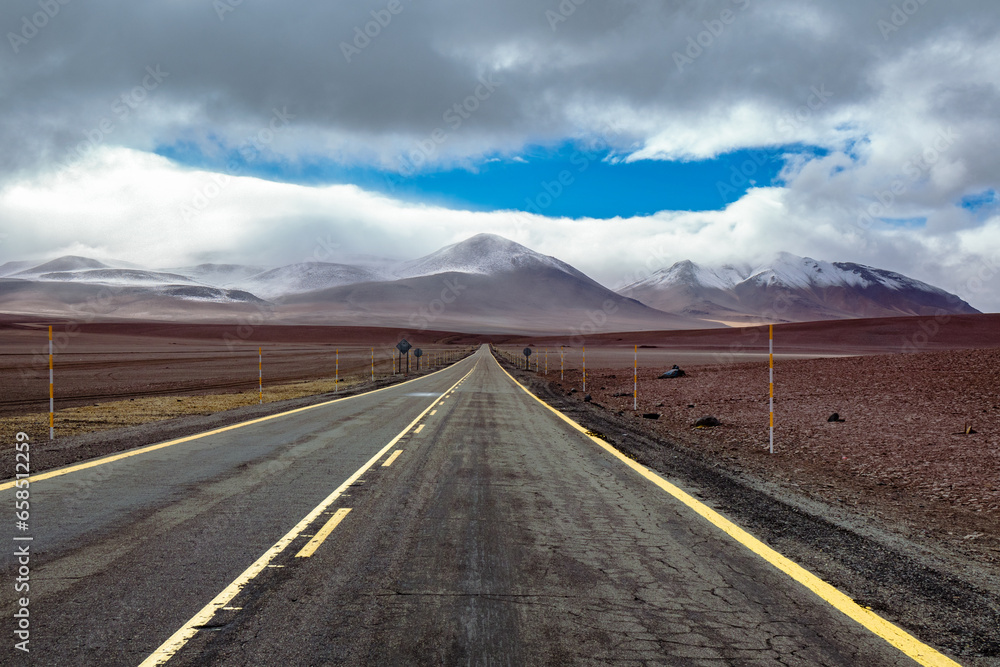 Fototapeta premium Road in Atacama desert savanna, mountains and volcano landscape, Chile, South America 