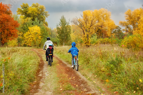 Family cycling in golden autumn park, active father and kids ride bikes, family sport and fitness with children outdoors  © Iuliia Sokolovska