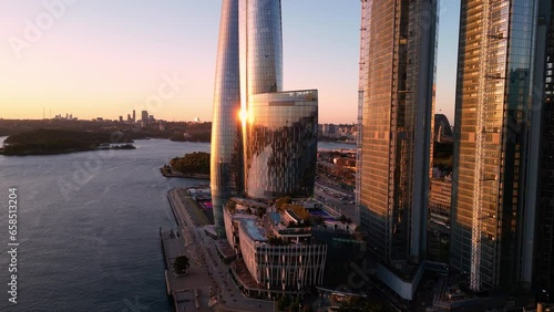 Sydney, Australia: Aerial drone footage of the stunning Sydney harbor with the iconic bridge with a revealing motion behind the new skyscrapers in Darling Harbor in Sydney at sunset. 