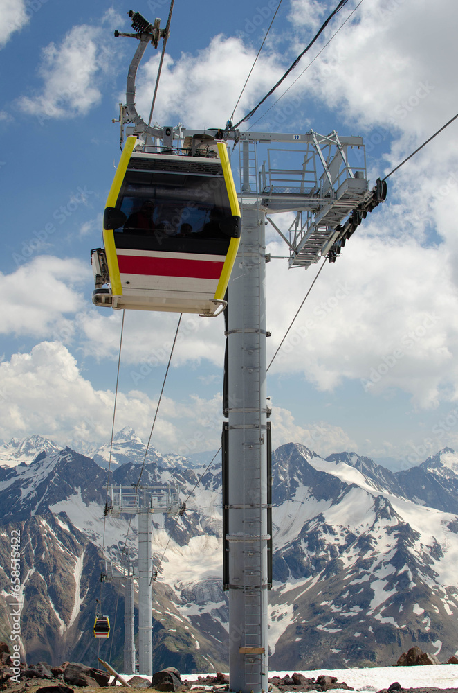 The cabin of a high-altitude cable car on the background of snow-capped mountains. A funicular in the mountains takes people to the top.