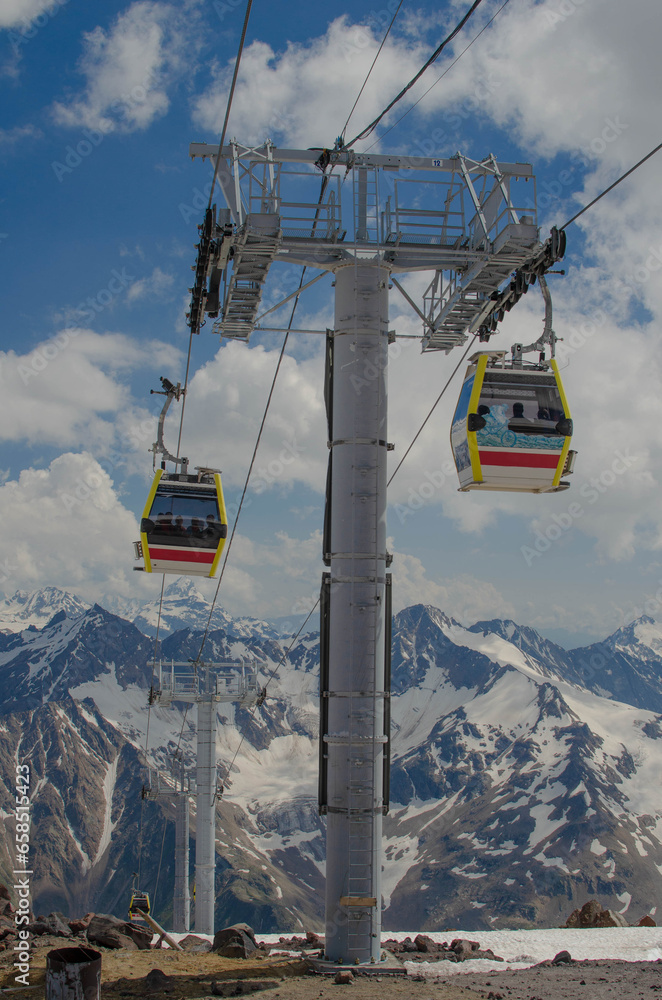 The cabin of a high-altitude cable car on the background of snow-capped mountains. A funicular in the mountains takes people to the top.