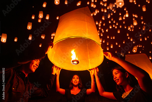 Asian couple traveller setting yi peng  lantern in loi krathong festivities