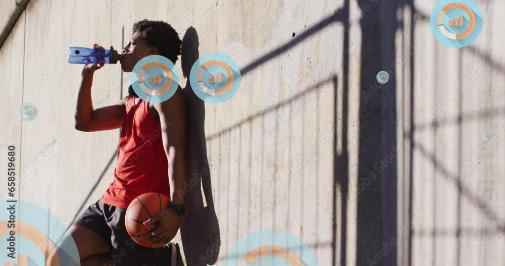 Animation of graphs, african american man with basket ball taking wall support and drinking water