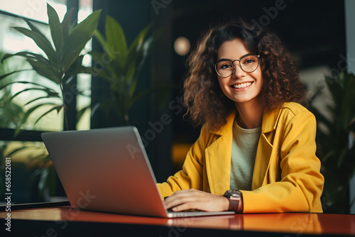 Beautiful young woman working laptop, student or freelancer sitting at cafe table, looking into camera.generated by AI model photo