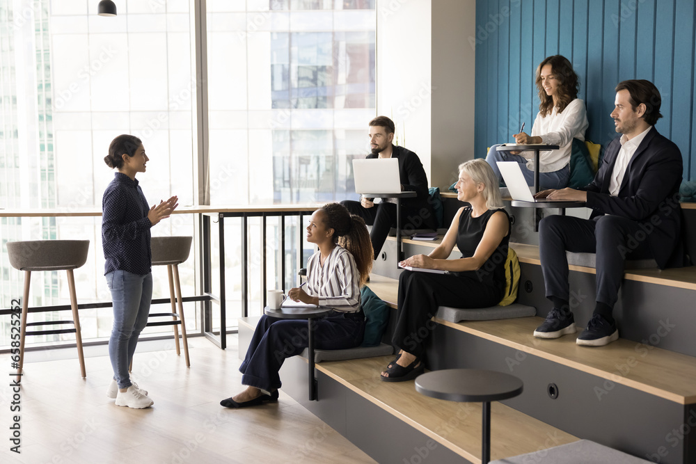 Φωτογραφία Young Indian business leader woman talking to diverse team of employees, small office staff in presentation room