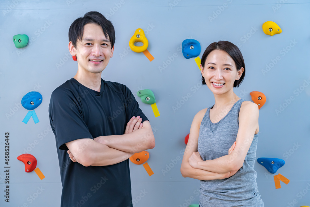 クライミングウォールの前でポーズをとる2人