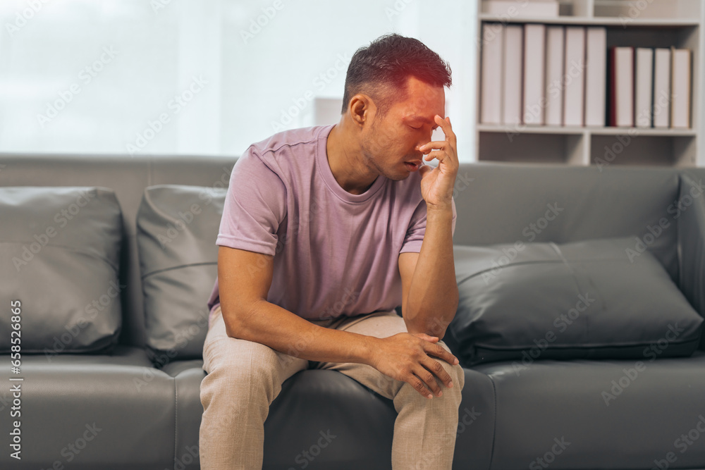 Middle-aged Asian Indian man with psychosis, depression, headache, migraine, sitting on sofa. Middle-aged Asian Indian man with psychosis, depression, headache, migraine, sitting on sofa.