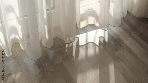 room lit by the morning sun, watch as shadows shift and light reflects off surfaces. The curtain sways gently in the breeze from the open window, adding to the sense of calm.