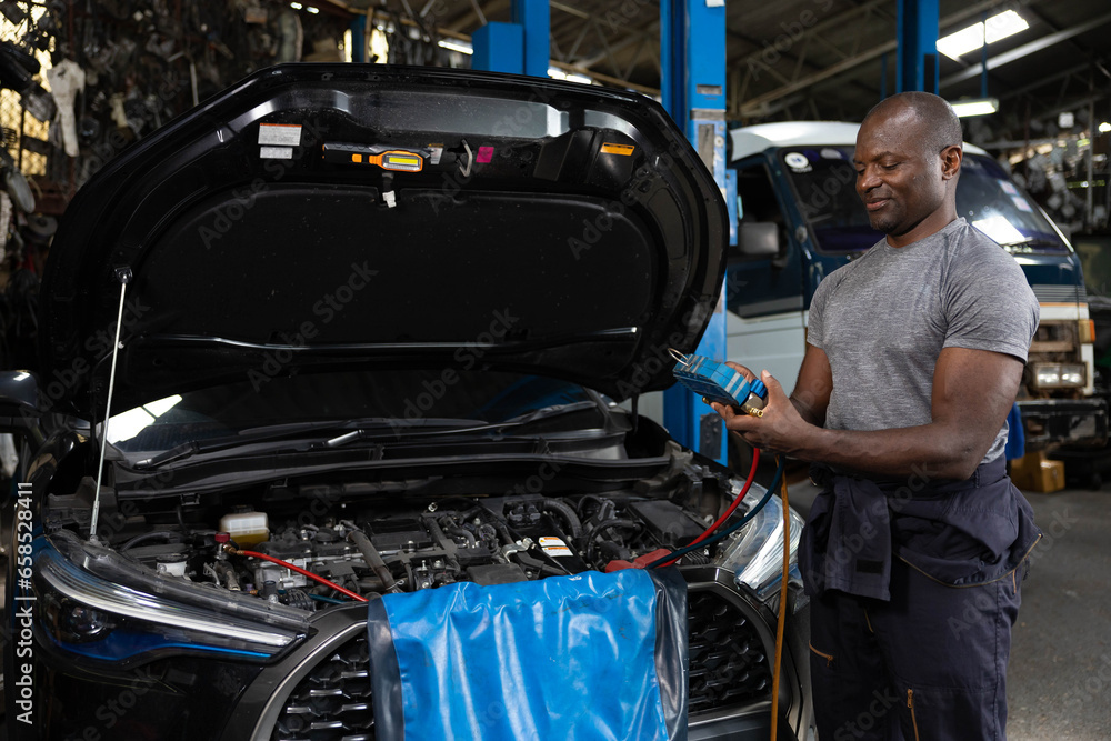 mechanic worker fixing and checking a car air conditioning system in automobile repair shop mechanic worker fixing and checking a car air conditioning system in automobile repair shop