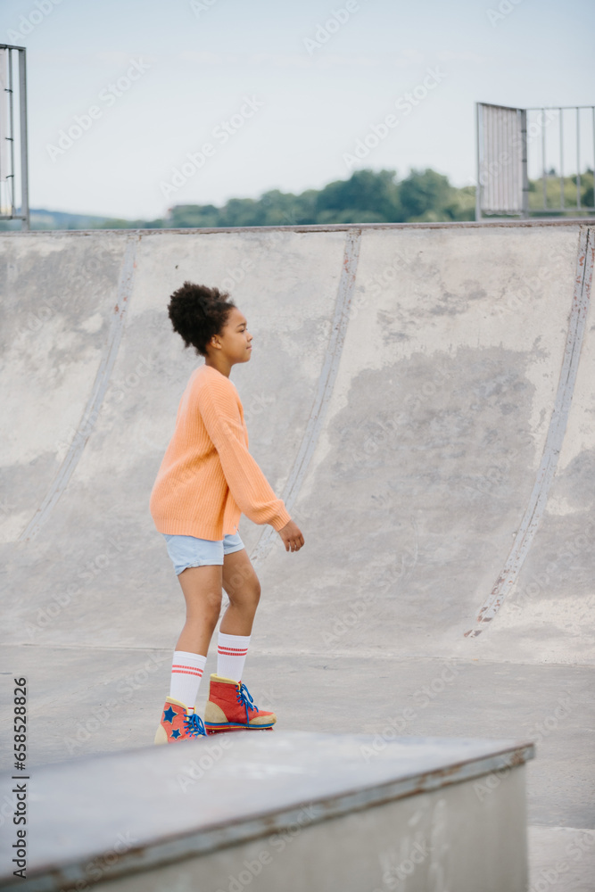 A teenage girl is rollerblading in a summer park. The concept of summer recreation outdoors. A teenage girl is rollerblading in a summer park. The concept of summer recreation outdoors.