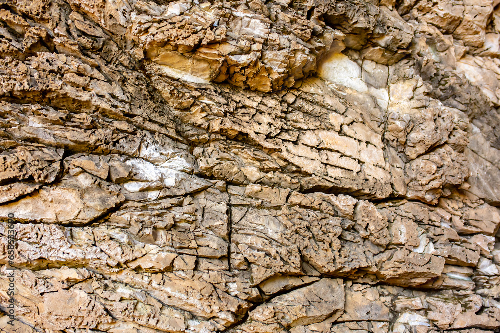 Natural rock texture background. Rocky bas-relief wall.