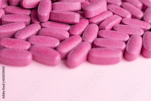 Vitamins and supplements for women on a pink background. Top view, flat lay. 