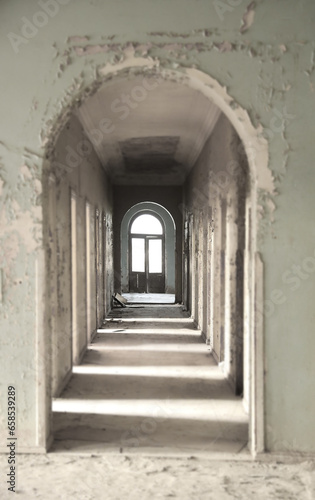 Horror hallway with little lighting background. Long empty dark corridor in abandoned building  perspective. Abandoned school  sanatorium  corridor perspective. many opened doors. destroyed in ruins