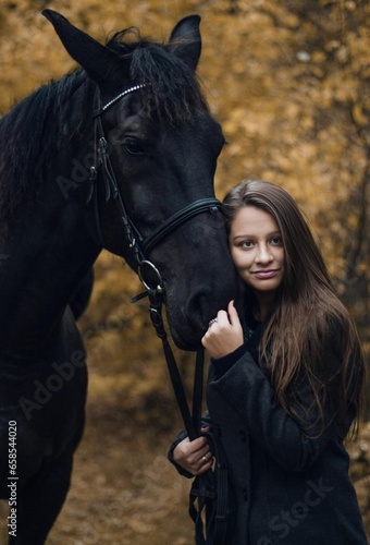 Cute girl with a stunning black horse