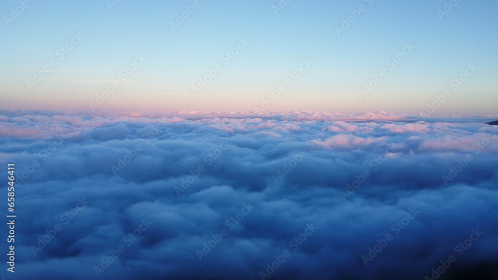 Aerial view over the mountains with sea of fog during morning sunrise in blue sky. Sea of clouds around mountain peaks at sunrise. Unseen travel in Northern Thailand