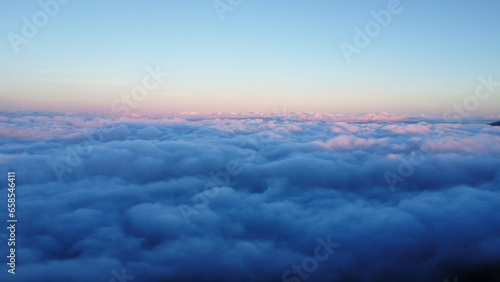 Aerial view over the mountains with sea of fog during morning sunrise in blue sky. Sea of clouds around mountain peaks at sunrise. Unseen travel in Northern Thailand