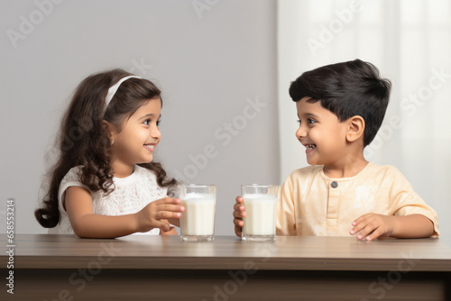 Indian little siblings drinking milk in glass photo
