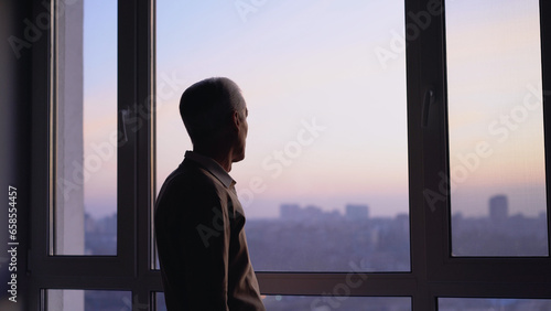 A lonely old man looking into the distance, waiting for relatives at a retirement home