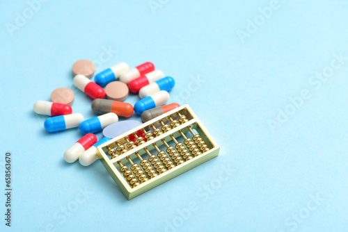 An abacus placed on a pile of drugs on a blue background