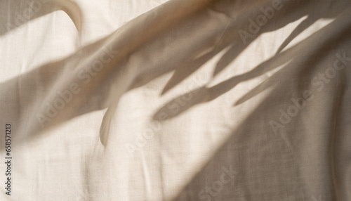 Aesthetic natural textile background with abstract sunlight shadow, neutral beige linen draped fabric, copy space photo
