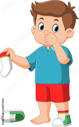 Standing boy kid holding dirty smelling sock in hand closing nose