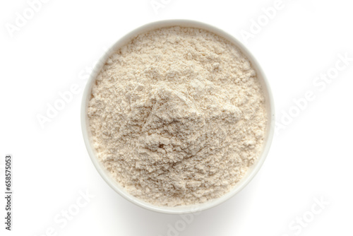 Bowl of organic Wheat flour (Triticum) isolated on a white background, top view.