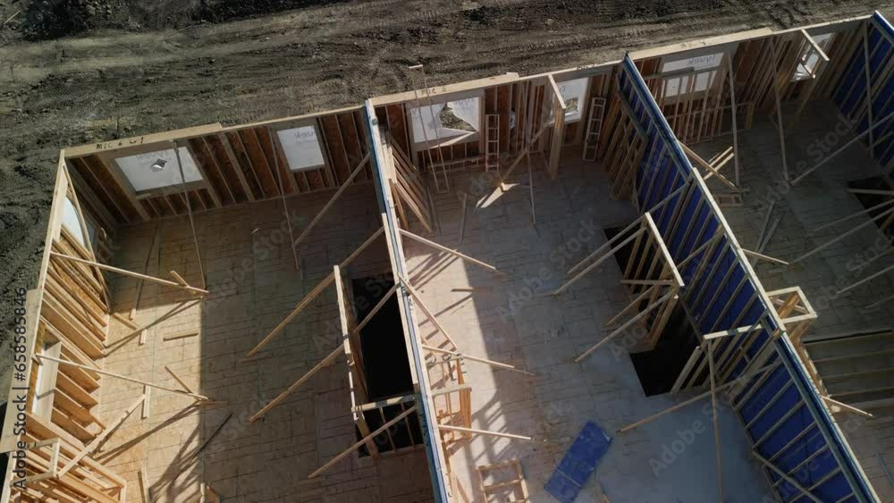 Aerial shot a new house under construction wood framing beams at sunny day Aerial shot a new house under construction wood framing beams at sunny day