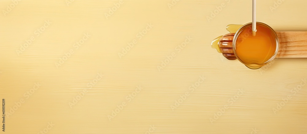 Wooden stick and golden honey on isolated pastel background Copy space