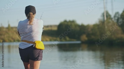 woman fishing in pond in autumn, back view