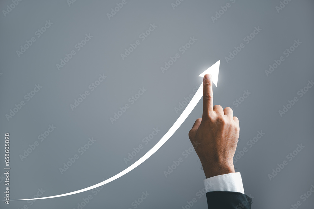 A businessman pointing hand guides an arrow on a graph, illustrating the corporate future growth plan. the concept of business development, growth, and the journey to success. A businessman pointing hand guides an arrow on a graph, illustrating the corporate future growth plan. the concept of business development, growth, and the journey to success.