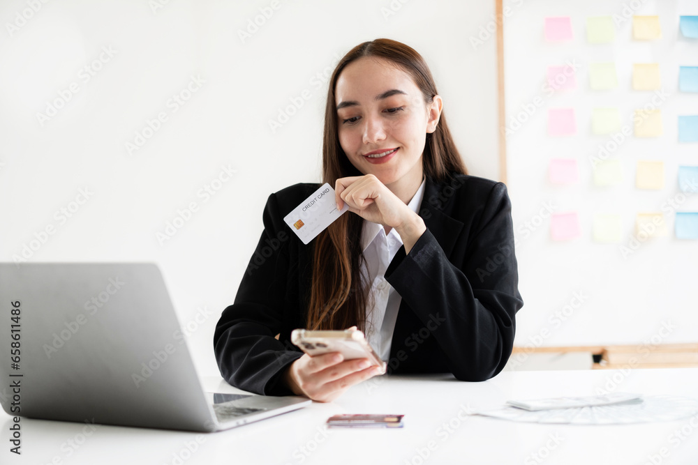 Asian girl shopping online holding credit and using smartphone enter their card number in the mobile phone app to purchase and payment in Internet store