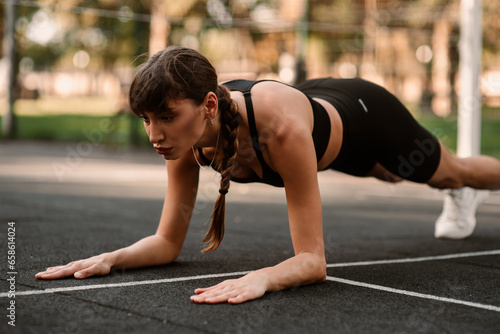 Fotografie A young female trainer performs a fitness compression exercise