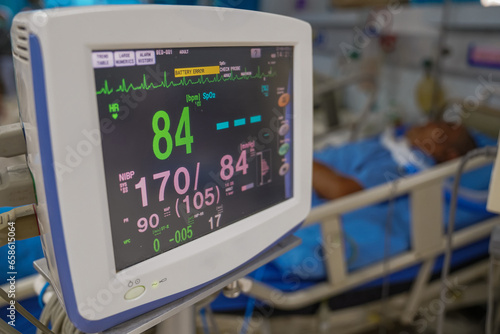 Modern vital sign monitor on patient background at ward in the hospital.