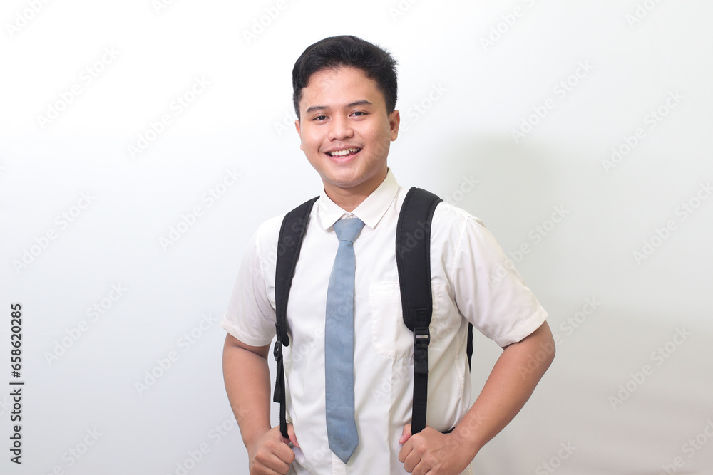 Indonesian senior high school student wearing white shirt uniform with gray tie smiling and looking at camera. Isolated image on white background Indonesian senior high school student wearing white shirt uniform with gray tie smiling and looking at camera. Isolated image on white background