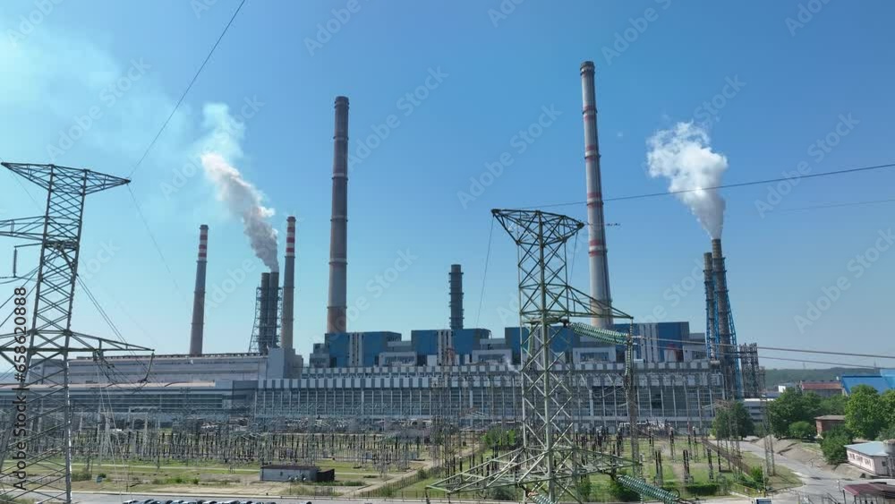 Aerial view of power plant chimneys, industrial area. Close-up of a smoking chimney. Old large thermal power plant in Europe. The production of electricity from coal pollutes the air. Factory landscap Aerial view of power plant chimneys, industrial area. Close-up of a smoking chimney. Old large thermal power plant in Europe. The production of electricity from coal pollutes the air. Factory landscap