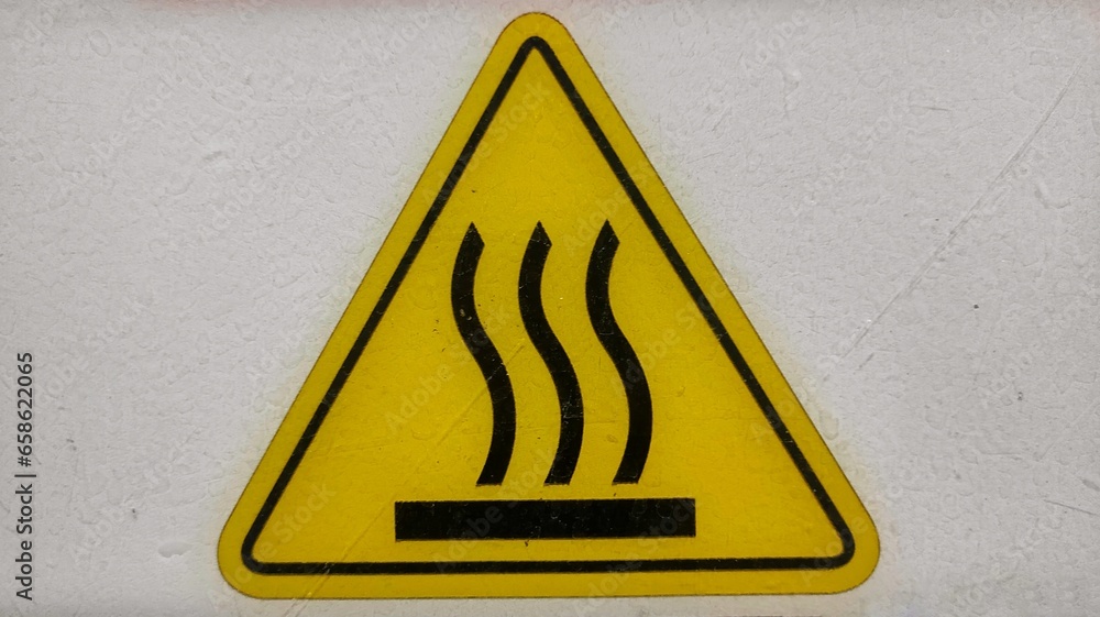 Hot surface sign sticker stick on the machine in production room of factory Hot surface sign sticker stick on the machine in production room of factory