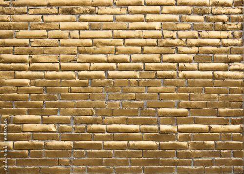the texture of a brick wall painted in a golden metallic color. grunge style design