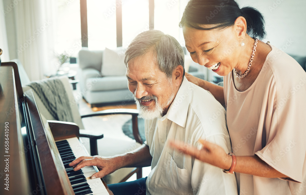 Senior couple playing piano for music in living room for bonding ...