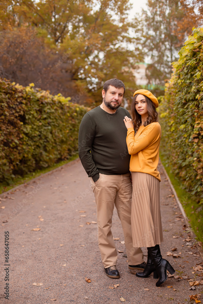 husband and wife in the autumn park on a walk husband and wife in the autumn park on a walk