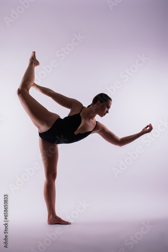 Young beautiful yoga female posing on a studio background